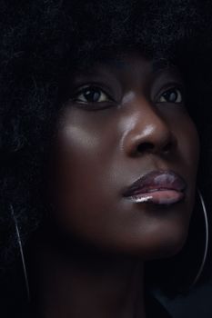 Close-up portrait capturing the serene expression of a woman with Afro hair.