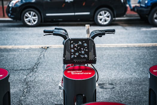 Capital Bikeshare bicycle docked at a city street with parked cars, highlighting urban commuting.