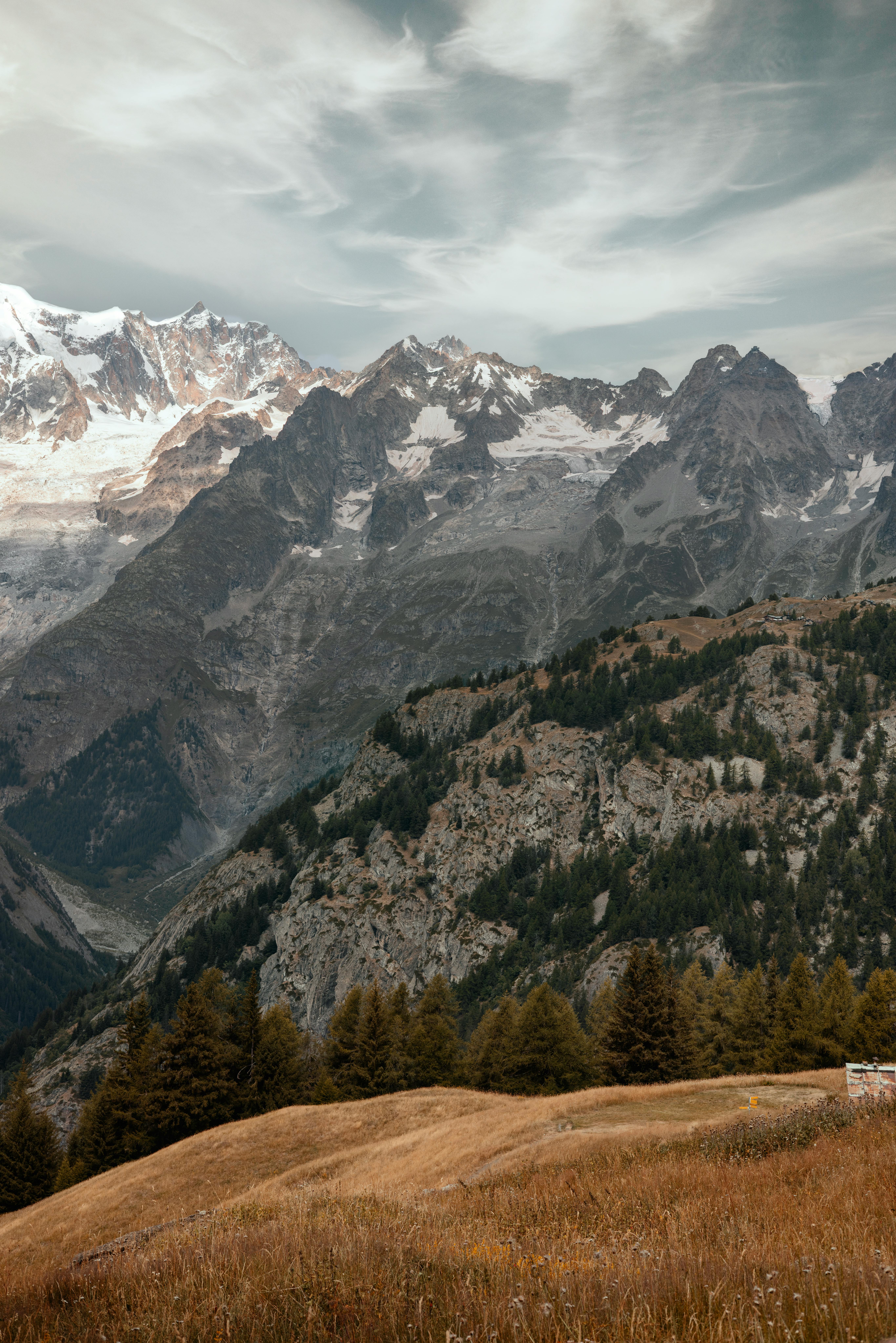 Stunning view of a majestic mountain range in an alpine landscape under a dramatic sky.