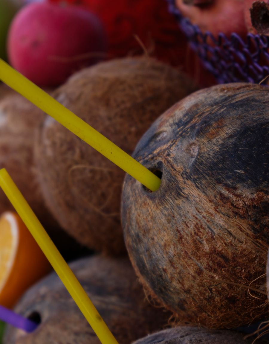 Fresh coconuts with straws at a tropical market.