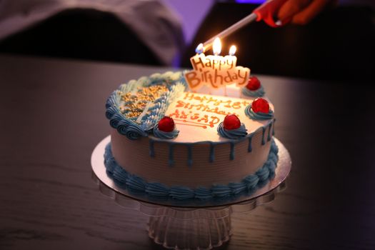 Celebrate a birthday with this beautifully decorated cake, complete with lit candles.