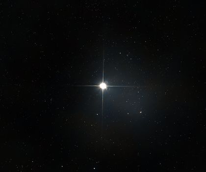 A bright star shines among countless stars in the vast, dark night sky.