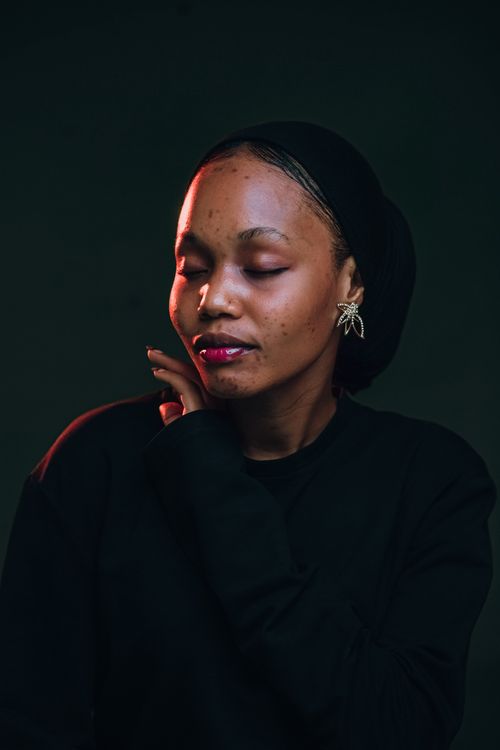 Free Portrait of an African woman with a serene expression, captured with dramatic lighting in Nigeria. Stock Photo