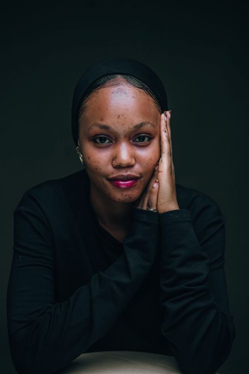 Free Captivating portrait of a young Nigerian woman wearing a black headscarf and top. Stock Photo