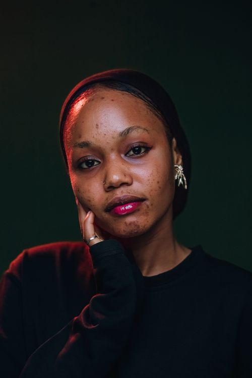 Free Striking portrait of a young Nigerian woman showcasing contemporary fashion in soft lighting. Stock Photo