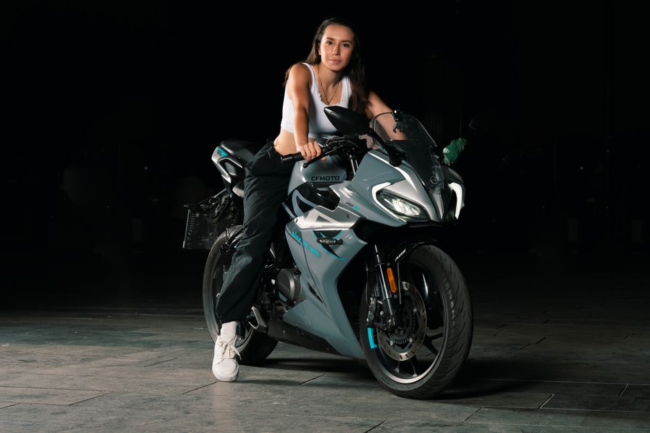 Confident woman sitting on a modern motorcycle in Istanbul during nighttime.