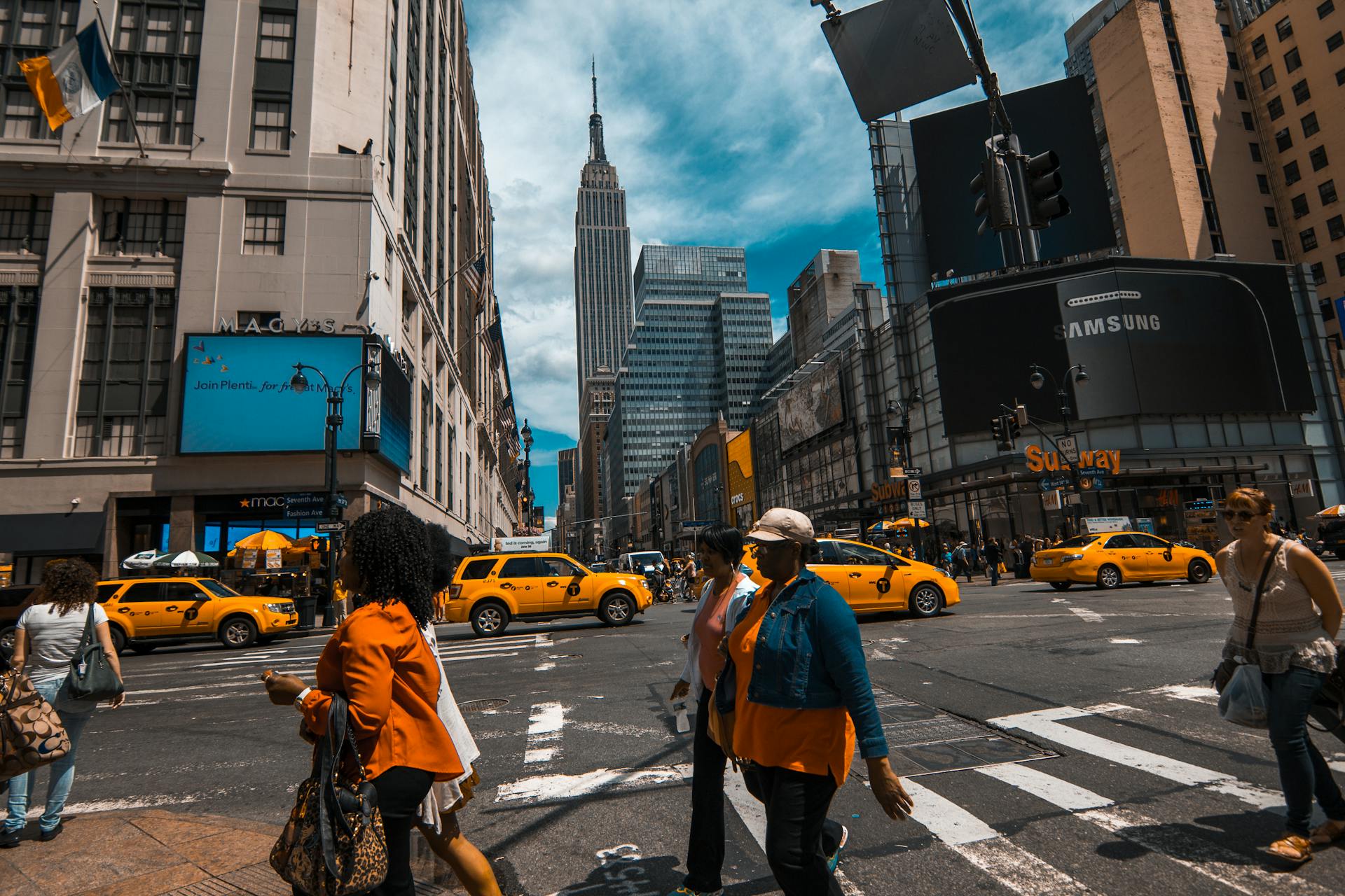 Bustling New York City street with yellow cabs and pedestrians crossing
