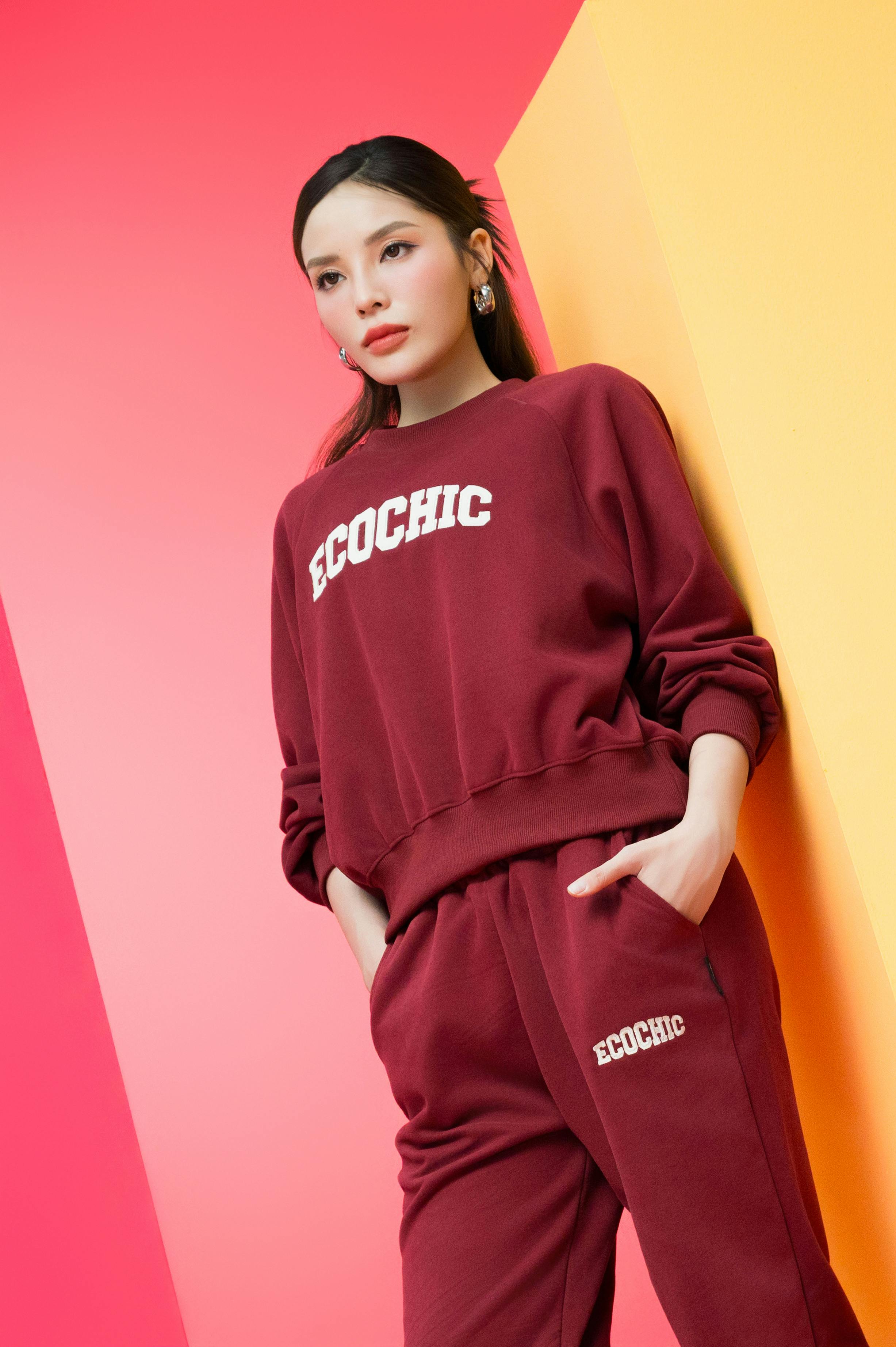 ฟรี ผู้หญิงมีสไตล์สวมชุดวอร์มสีเบอร์กันดีเป็นมิตรต่อสิ่งแวดล้อมบนพื้นหลังสีสันสดใส คลังภาพถ่าย