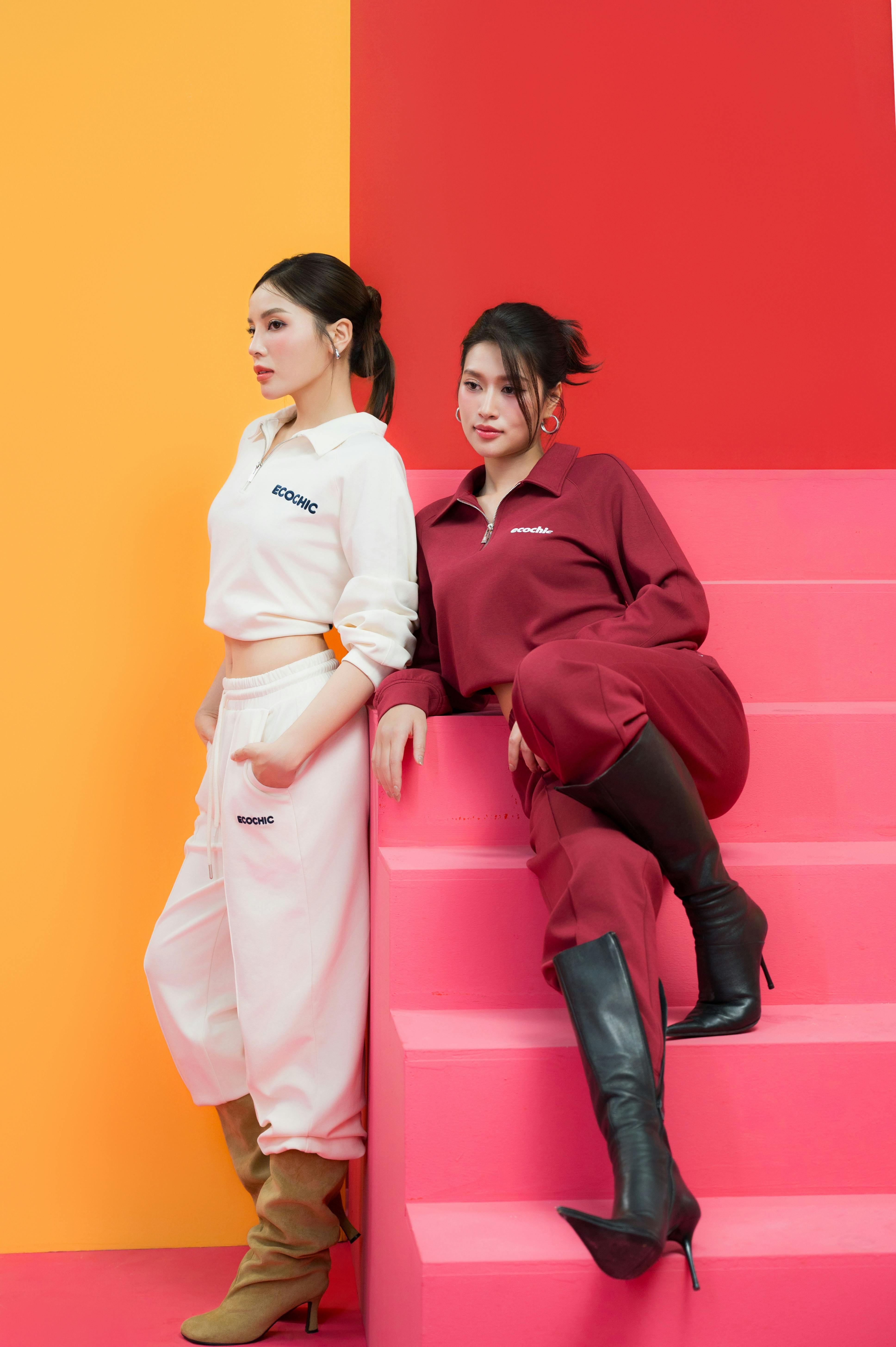 Kostenlos Zwei modische Frauen posieren in stylischen Outfits auf einer bunten Treppe. Stock-Foto