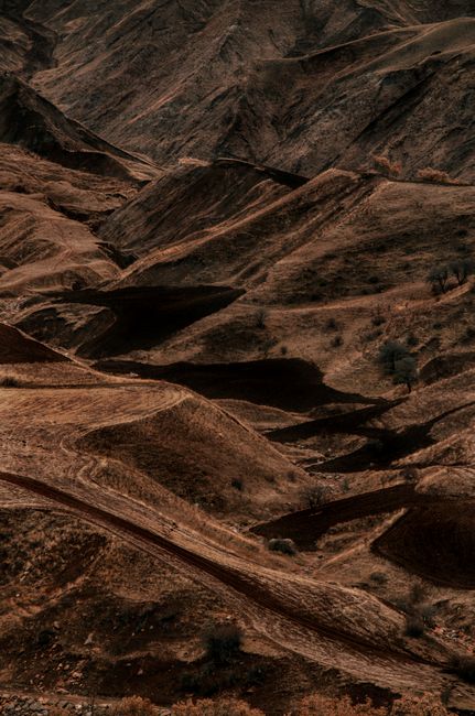 Explore the dramatic textures and hues of an arid desert landscape captured at sunset. Perfect for adventure and travel themes.