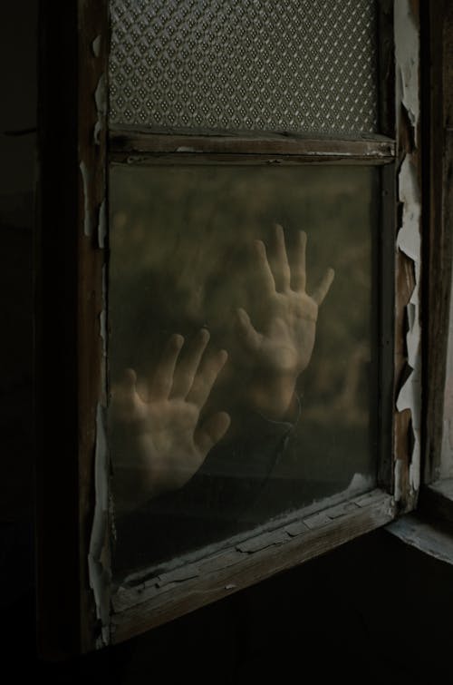 Unknown Person Putting Hands on Glass Window