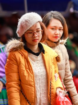 Two women exploring a vibrant traditional market in Lào Cai, Vietnam.