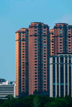 Tall high-rise buildings with a clear blue sky, showcasing urban architecture.