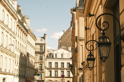 Free Explore a picturesque Paris street showcasing elegant classic architecture under a bright sky. Stock Photo