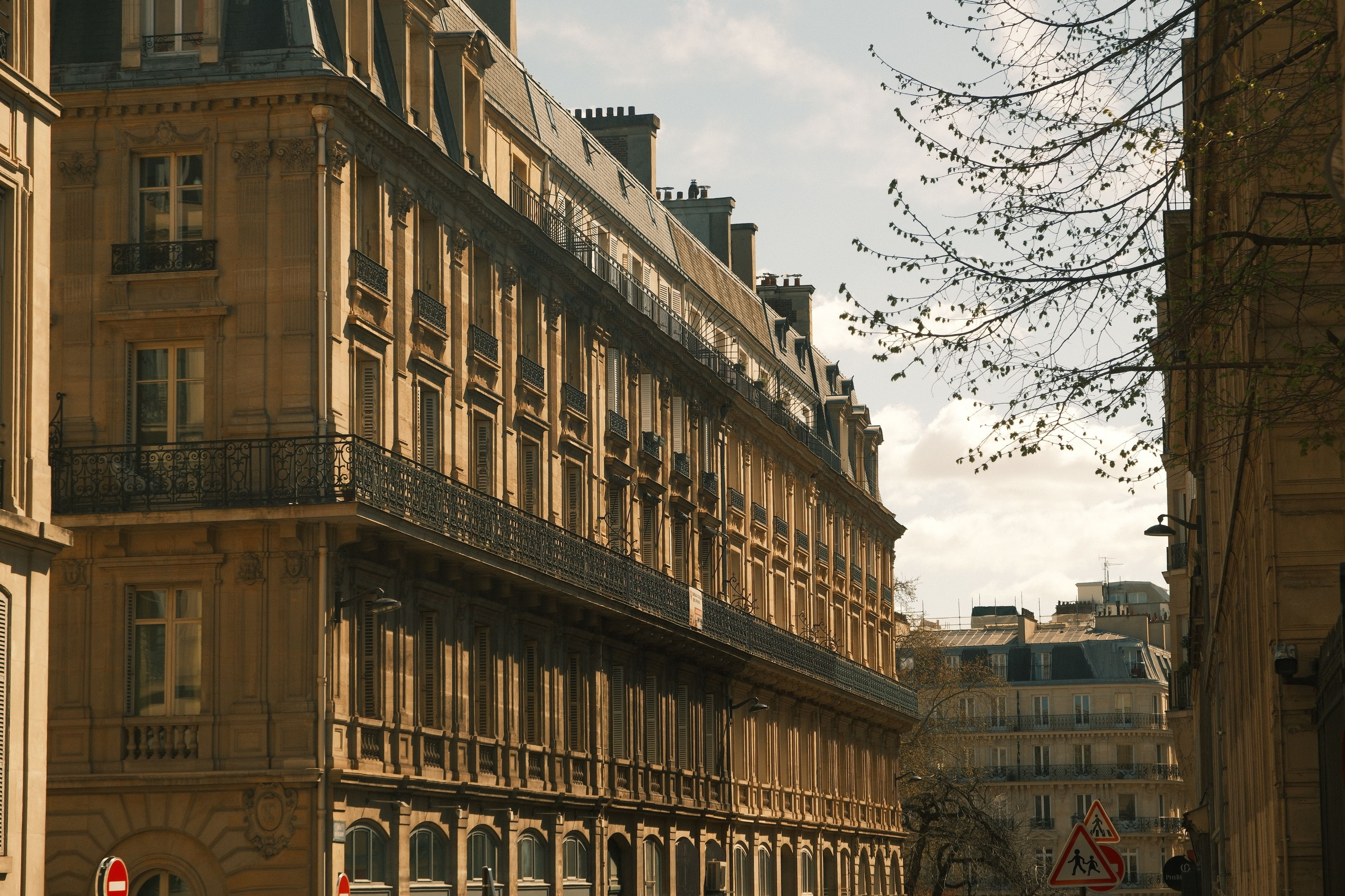 Immeuble parisien classique éclairé par une lumière de printemps basse.