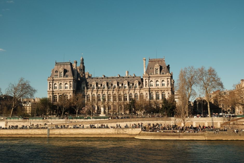 Elegant view of a classic Parisian building along the Seine River on a clear day.
