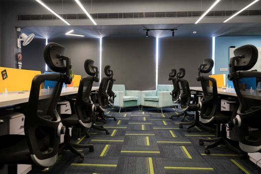Spacious modern office with ergonomic chairs and bright decor, perfect for a productive work environment.