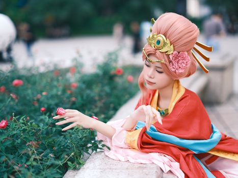 Woman in ornate costume with roses, blending elegance and tradition.