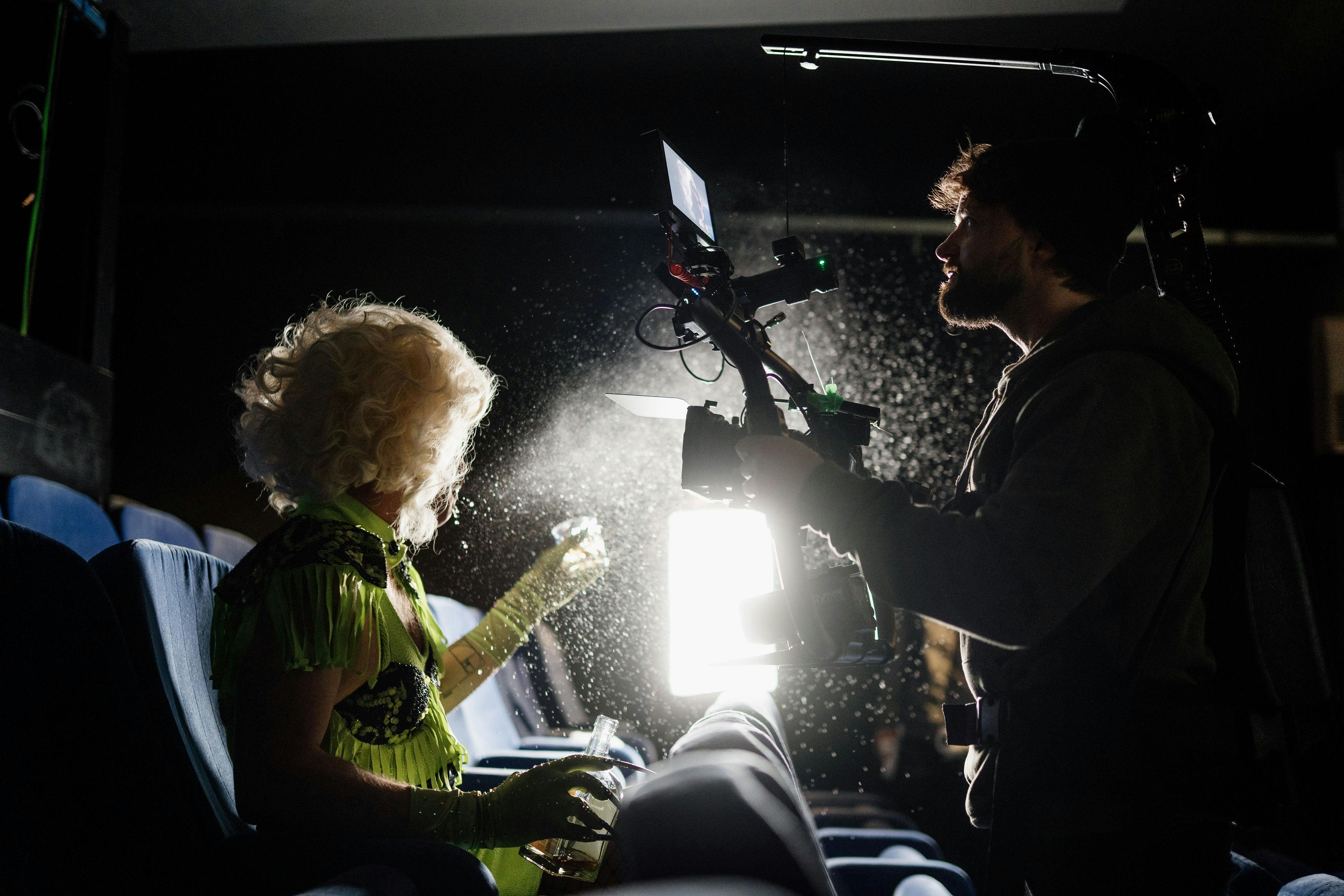Free Filmmaker capturing a scene in a dimly lit theater with dramatic lighting effects. Stock Photo