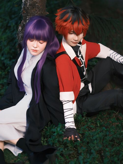 Free Two individuals in colorful cosplay outfits in an outdoor setting with lush greenery. Stock Photo