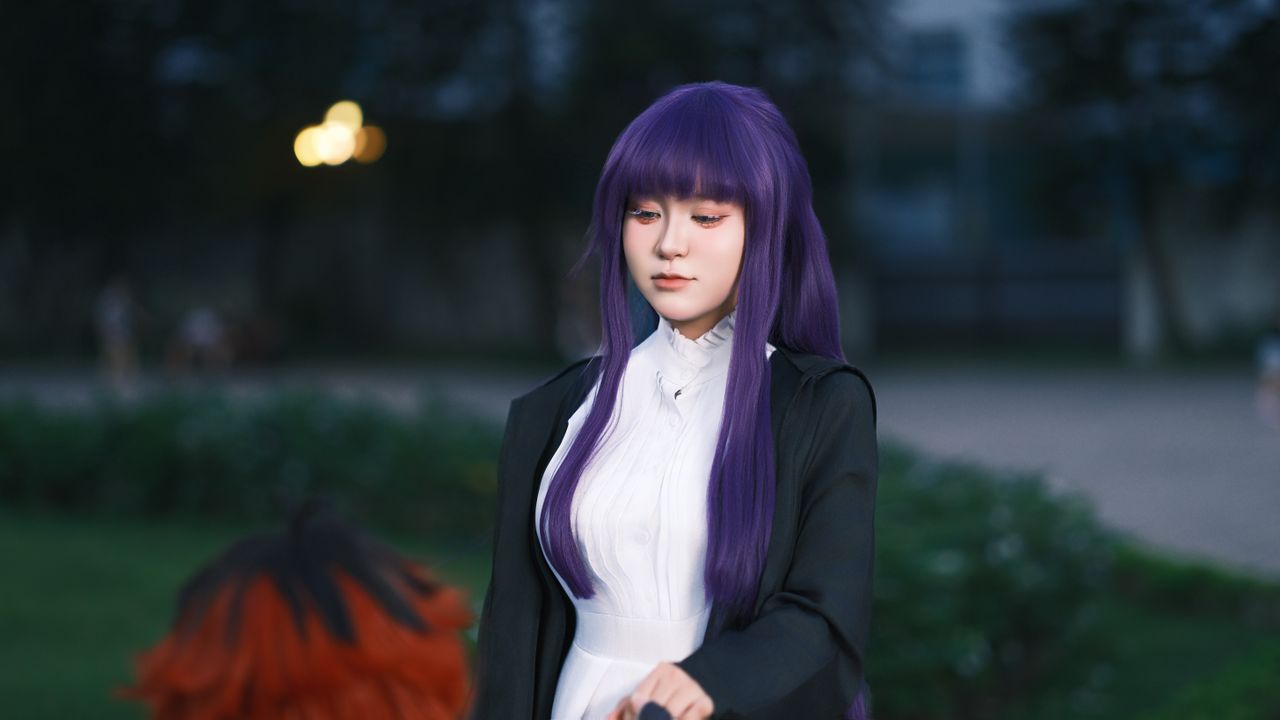 a person dressed in cosplay with purple hair and elegant attire standi