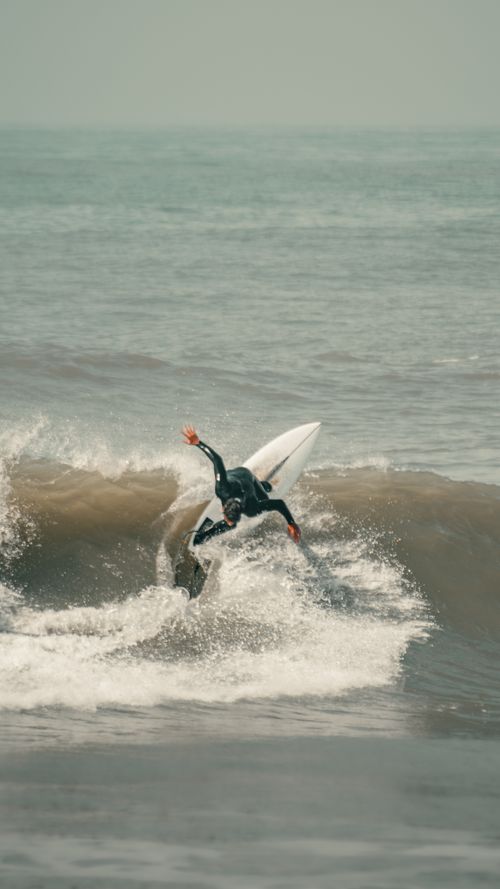 Free Dynamic surfer conquering waves in Mar del Plata, Argentina. Stock Photo
