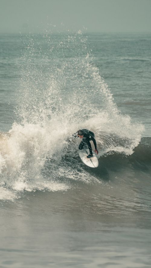 Free Surfer performing an impressive maneuver on ocean wave in Mar del Plata, Argentina. Stock Photo