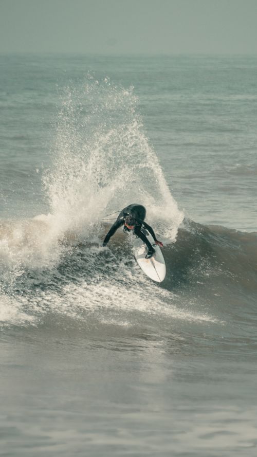 Free Dynamic shot of a surfer expertly riding a wave in Mar del Plata, Argentina. Stock Photo