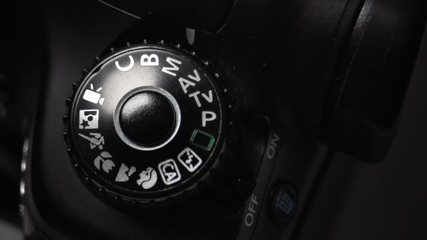 Detailed close-up of a DSLR camera mode dial showing various settings.