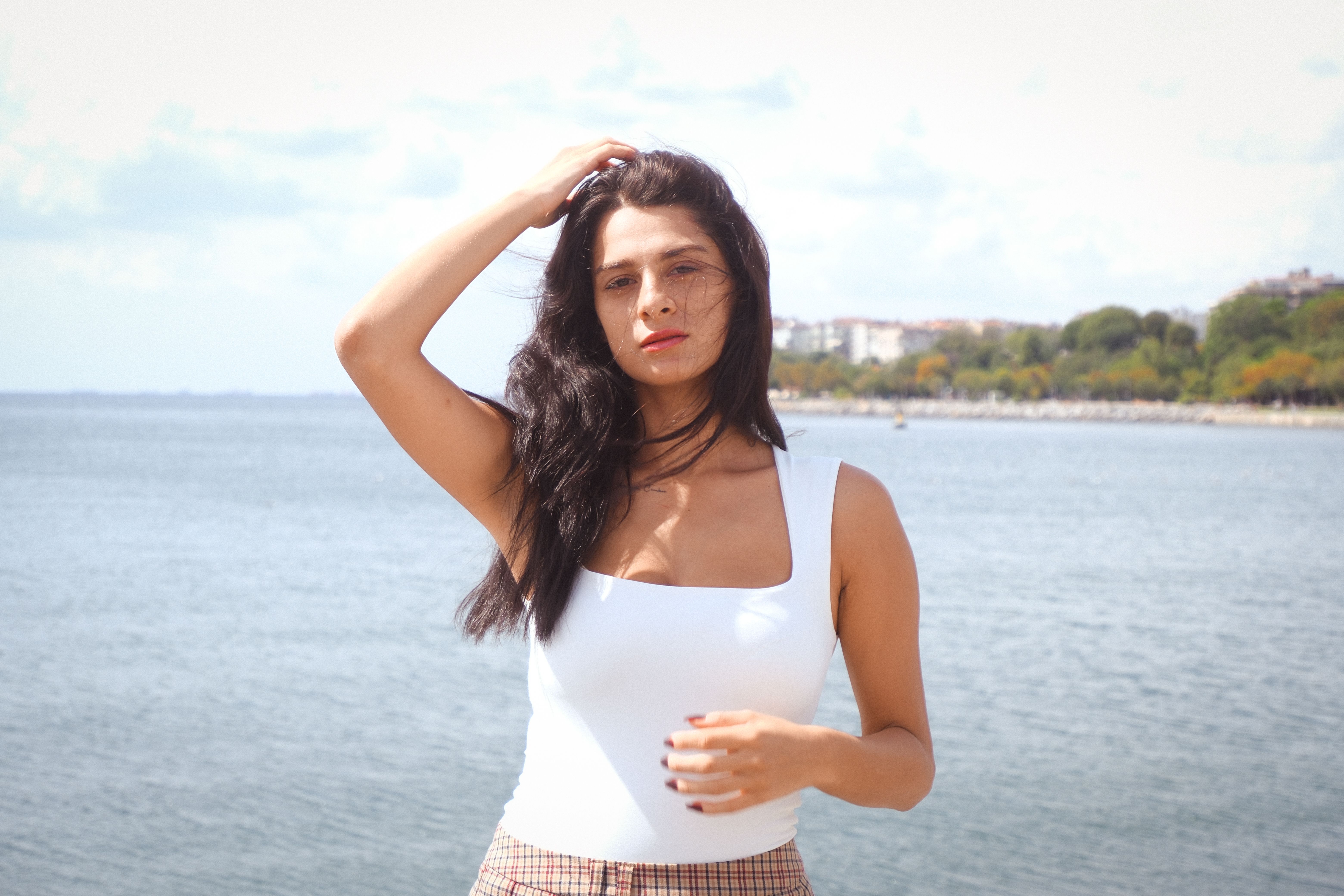 Woman in white top posing by the sea in Istanbul, Türkiye.