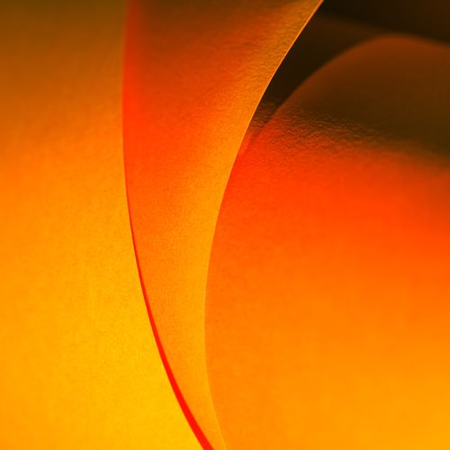 Free Dynamic abstract image of orange paper curves creating a vibrant pattern. Stock Photo