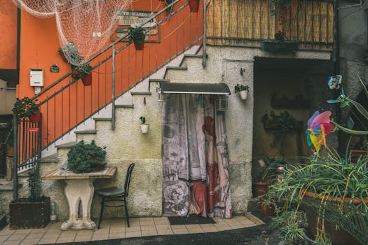 Colorful courtyard featuring stairs, plants, and vibrant decor in a Mediterranean setting.