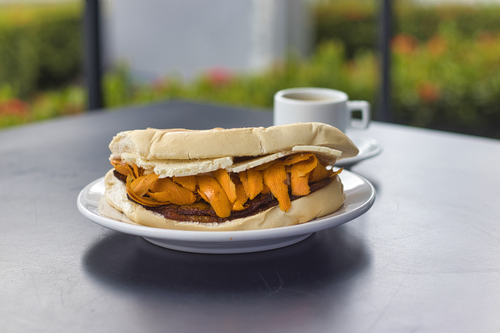 Free Savory Brazilian sandwich with cheese and coffee on a table in Manaus. Stock Photo