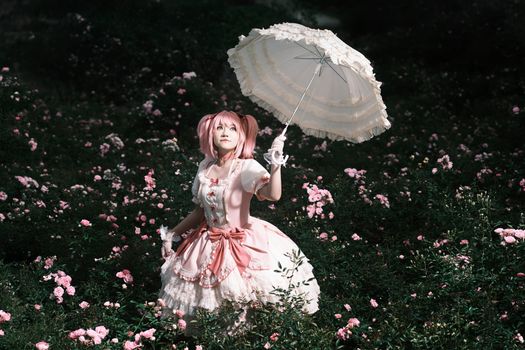 Cosplay character with a parasol among blooming flowers in summer.