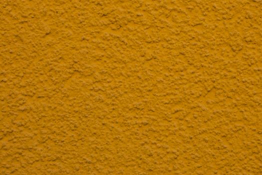 Close-up of a textured yellow plaster wall, ideal for backgrounds or design projects.