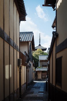 Scenic view of a narrow alley leading to a pagoda in a traditional Japanese neighborhood.