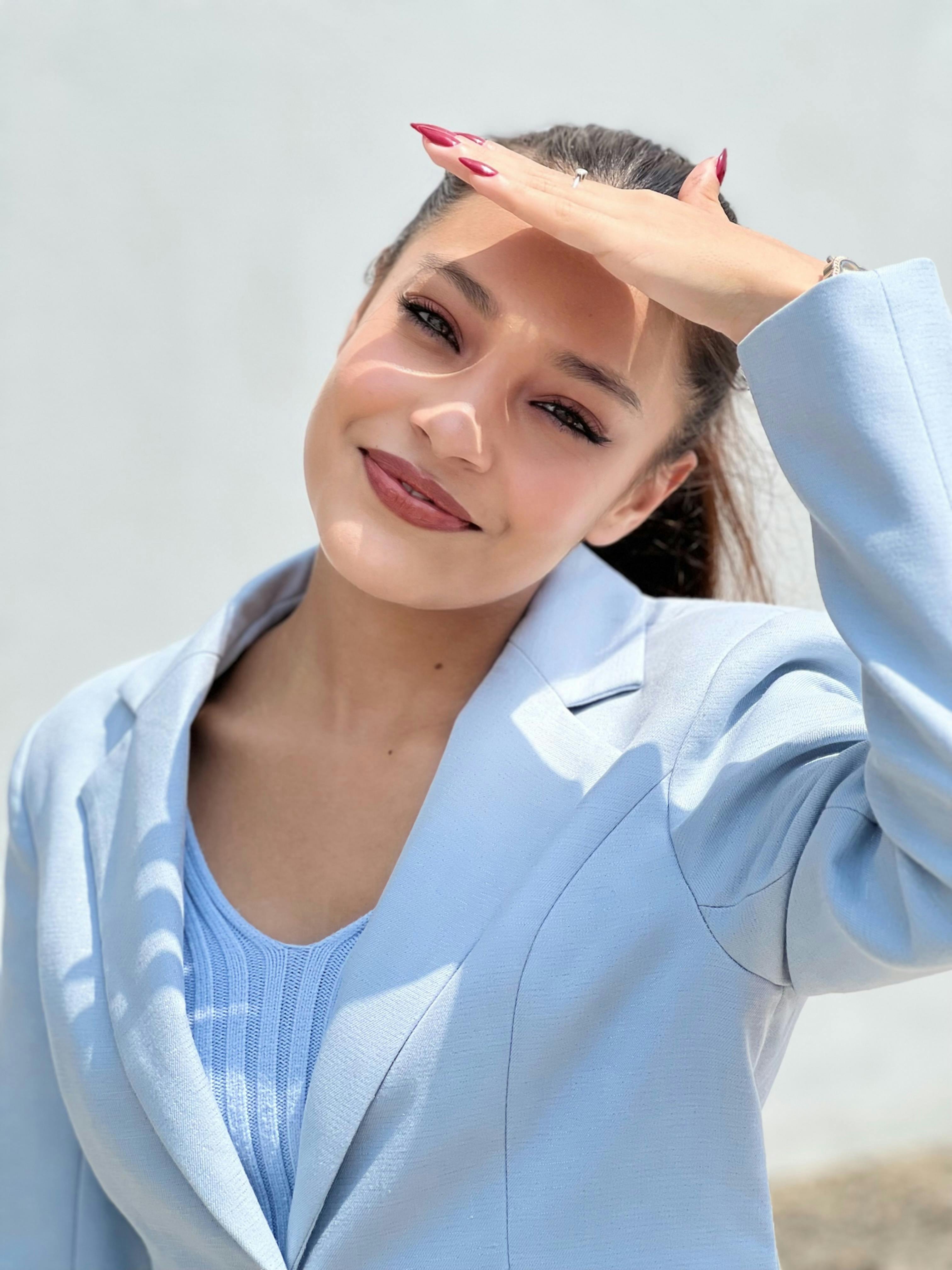Donna in blazer blu che sorride all'aperto in luce naturale