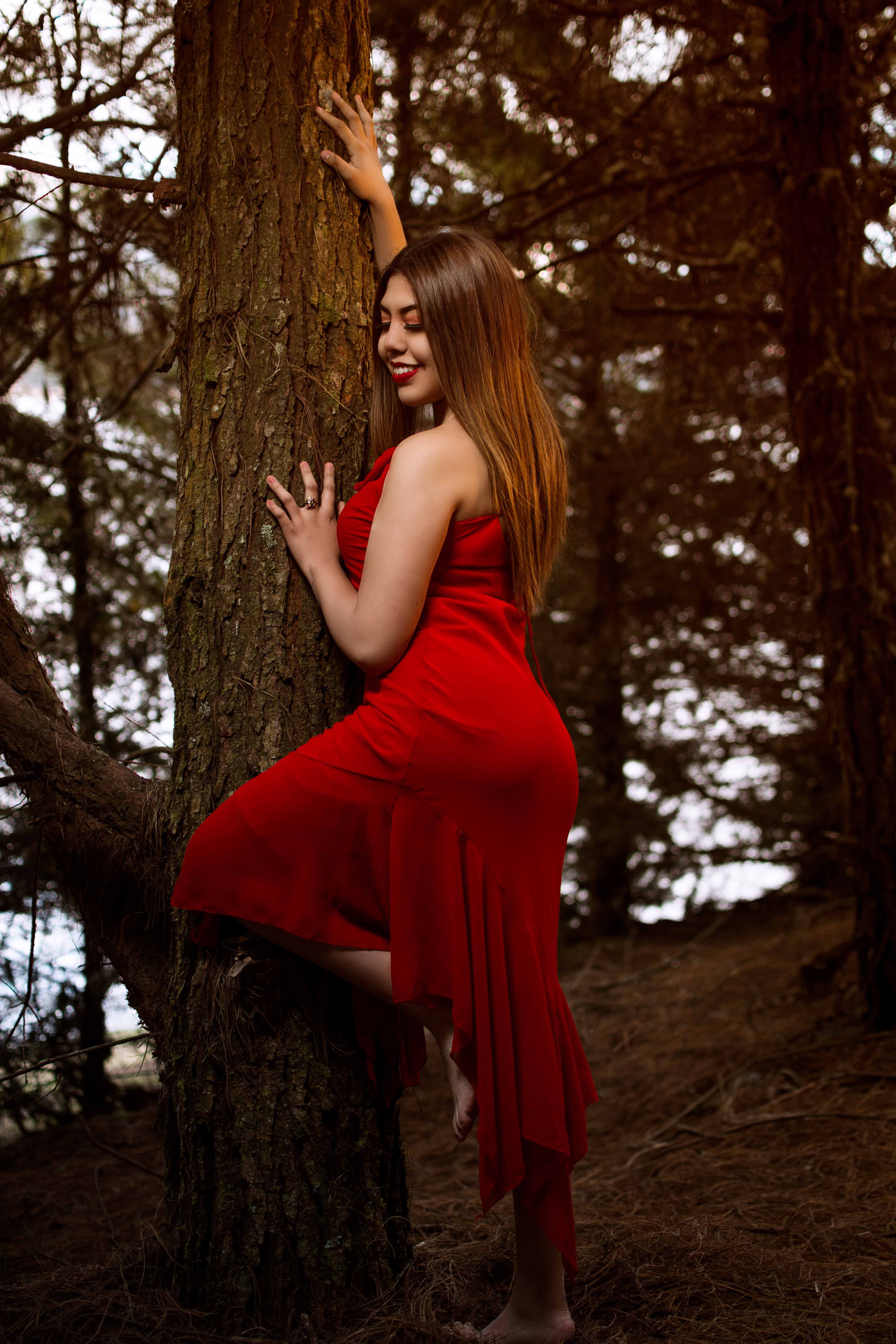 Woman in Red Dress Posing in Forest Setting · Free Stock Photo
