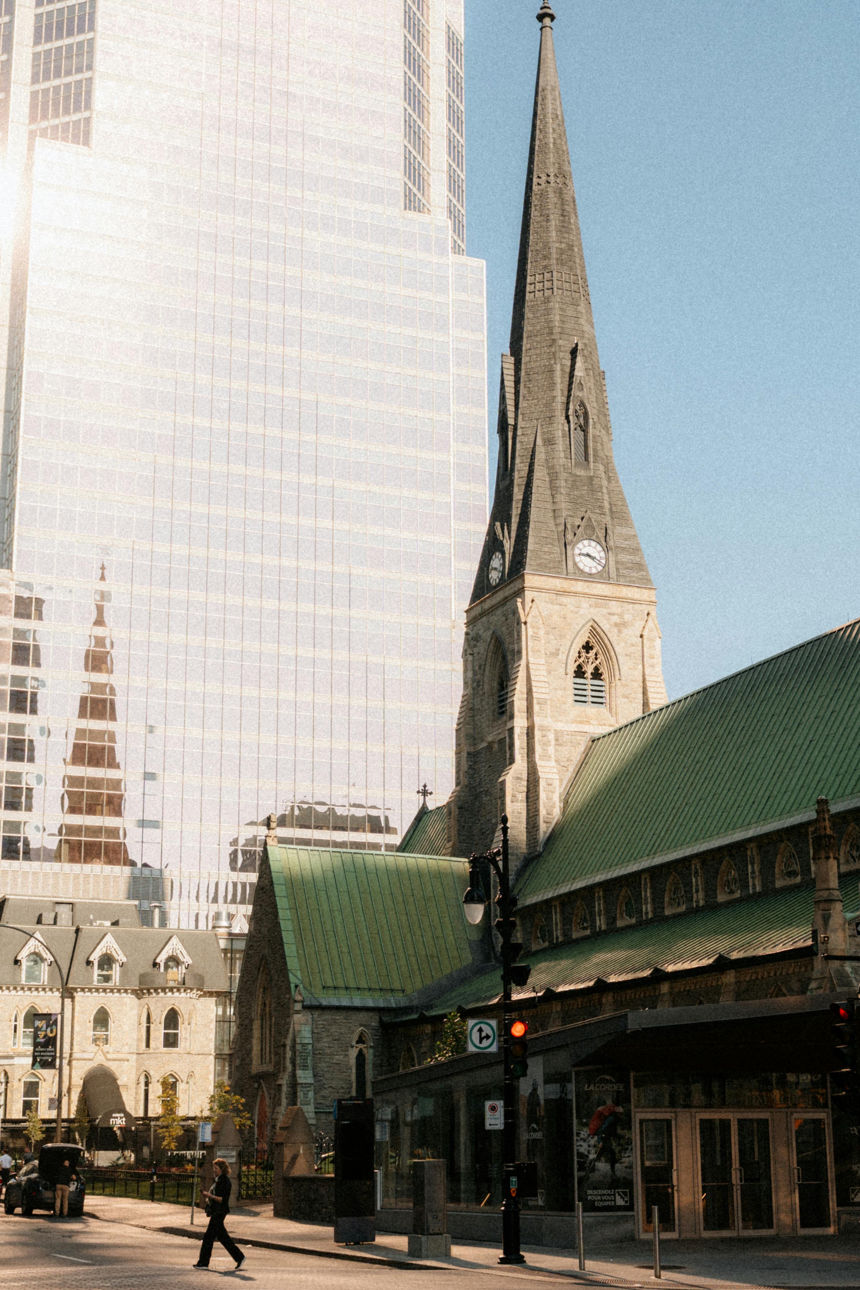 Stunning blend of historic architecture and modern skyscraper in downtown Montréal, Québec under clear skies.