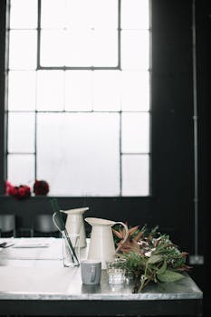 房间明亮，布置着窗户、桌子、装饰和花卉