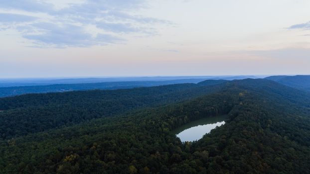 A stunning aerial view of a forest and lake in Pelham, Alabama during daytime.