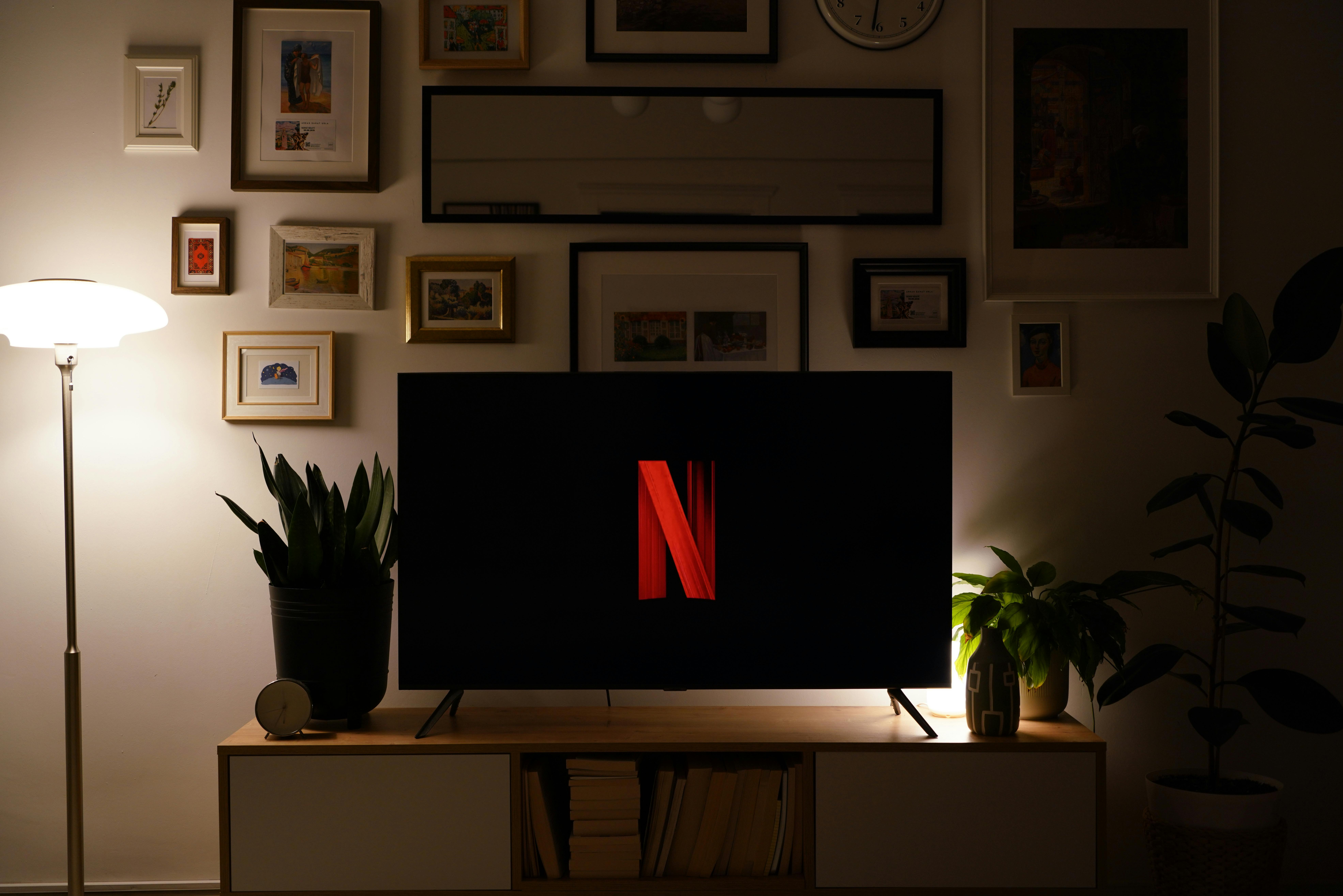 Televisore acceso in salotto che mostra interfaccia di streaming Netflix