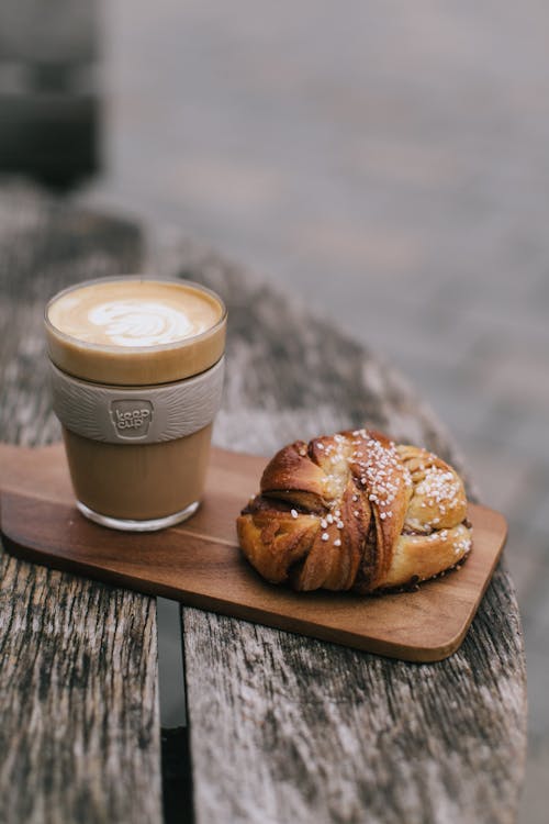 Bread and Clear Glass Cup on Wooden Board