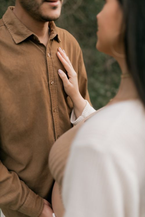 Free A warm and intimate moment captured between a pregnant couple outdoors, symbolizing love and anticipation. Stock Photo