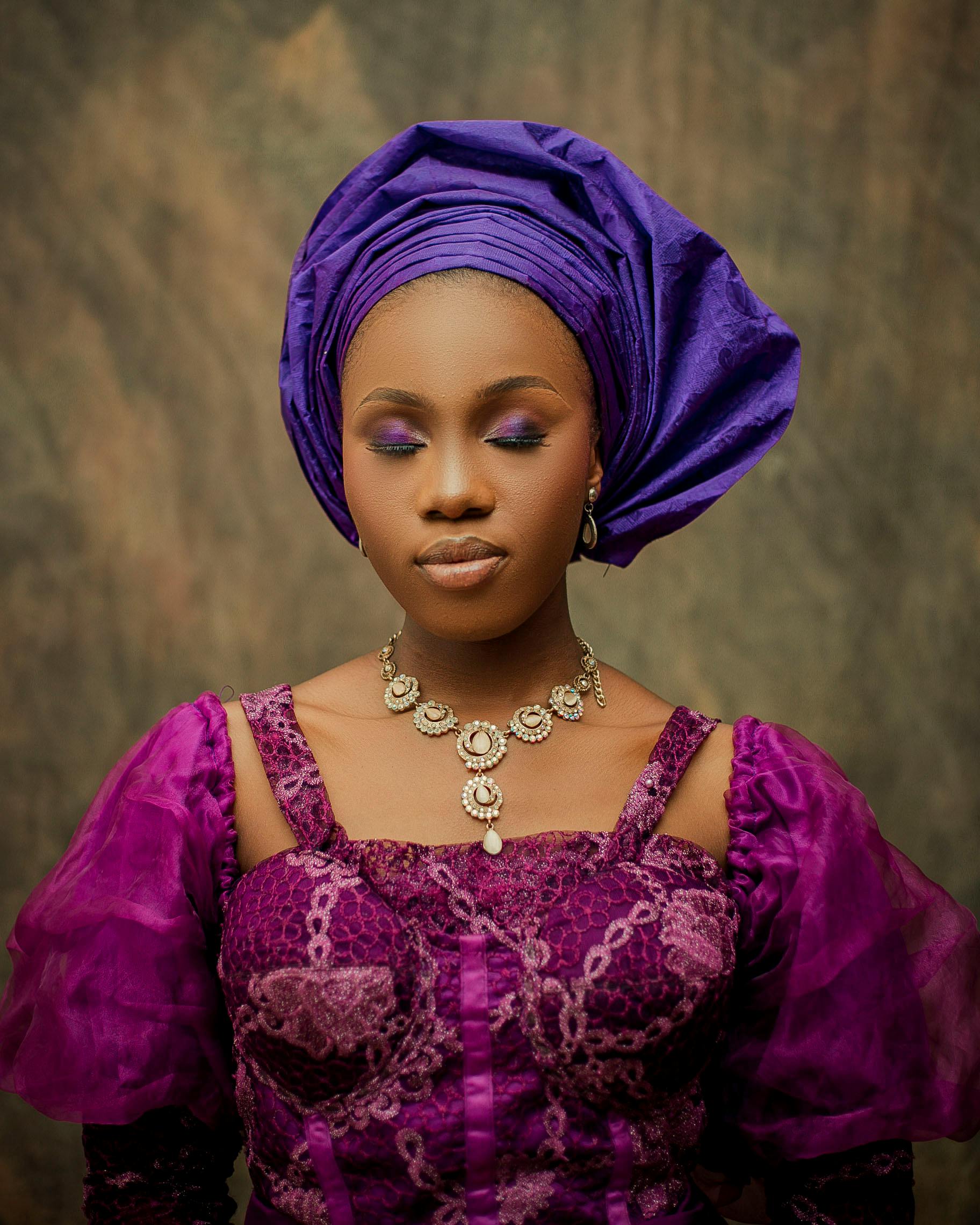 Gratis Ritratto di una donna in abito tradizionale nigeriano con un elaborato copricapo viola. Foto a disposizione