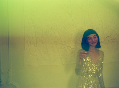 Woman Standing Leaning on Wall Holding Wine Glass