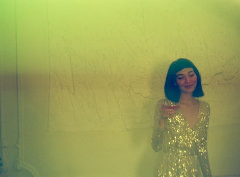 一位身着闪亮礼服的女士，在室内时尚鸡尾酒会上高兴地举杯