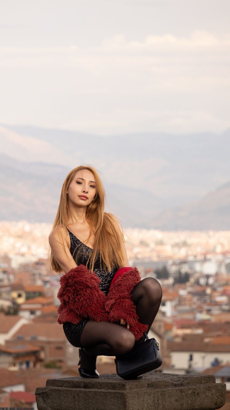 Woman in red fur jacket with cityscape backdrop