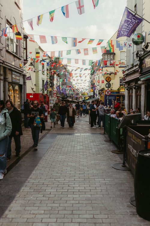 Free Lively street in Galway, Ireland with people and colorful flags on display. Stock Photo