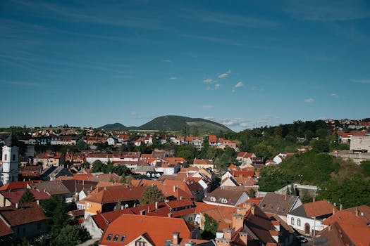 Beautiful aerial view of Veszprém, Hungary, showcasing red tiled roofs and green hills.